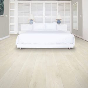 Bright bedroom with white bedding and light laminate floors